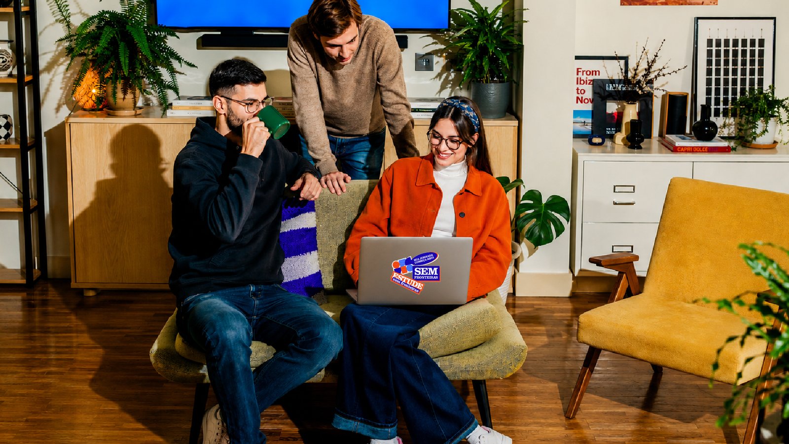 Estudantes reunidos em uma sala com um notebook